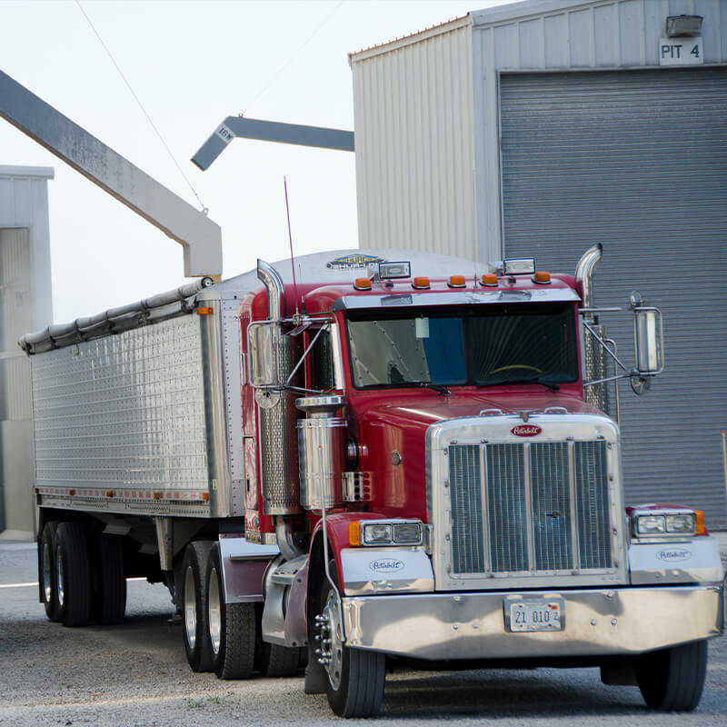 Semi truck leaving warehouse with a loaded trailer.